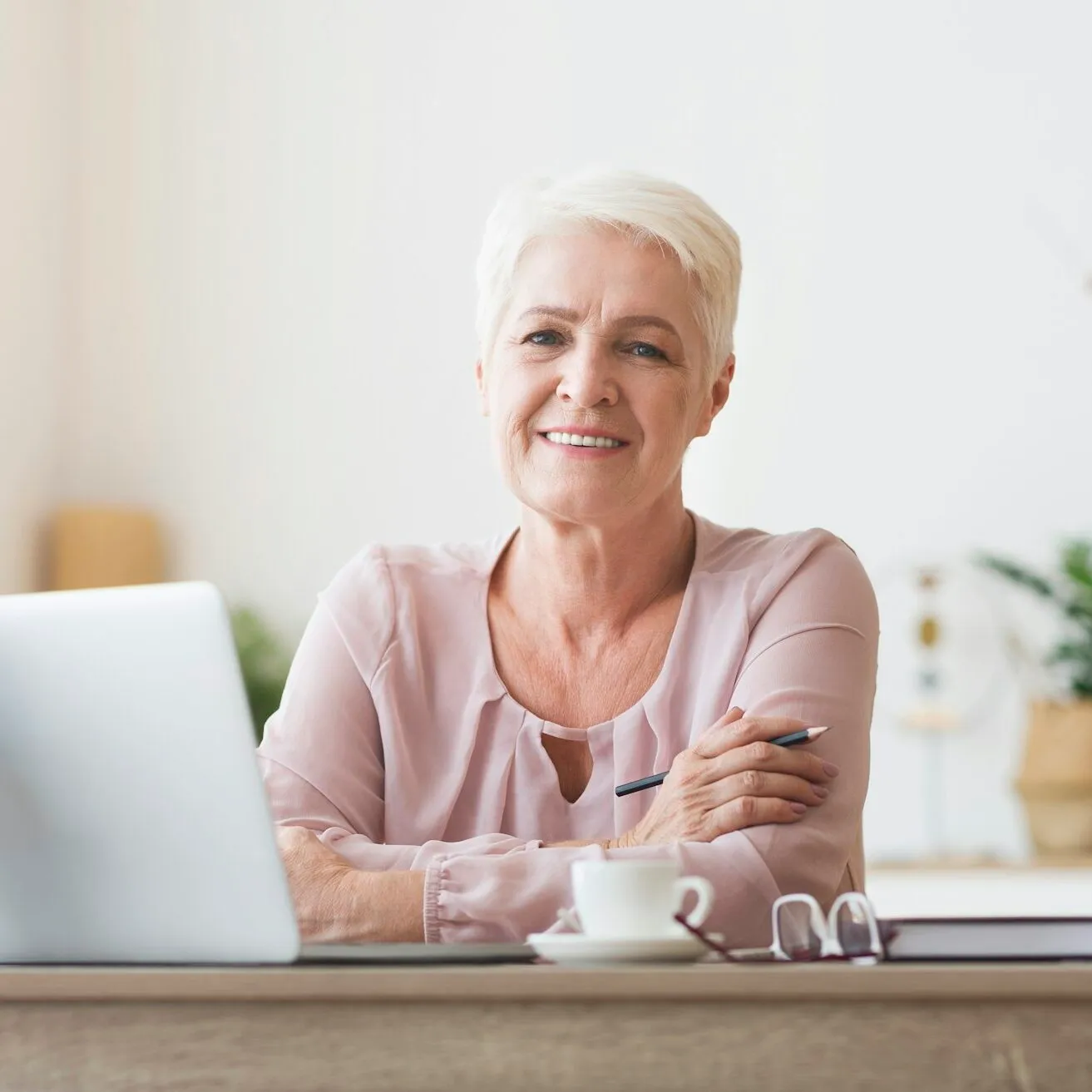 Attractive old lady posing at workdesk at home